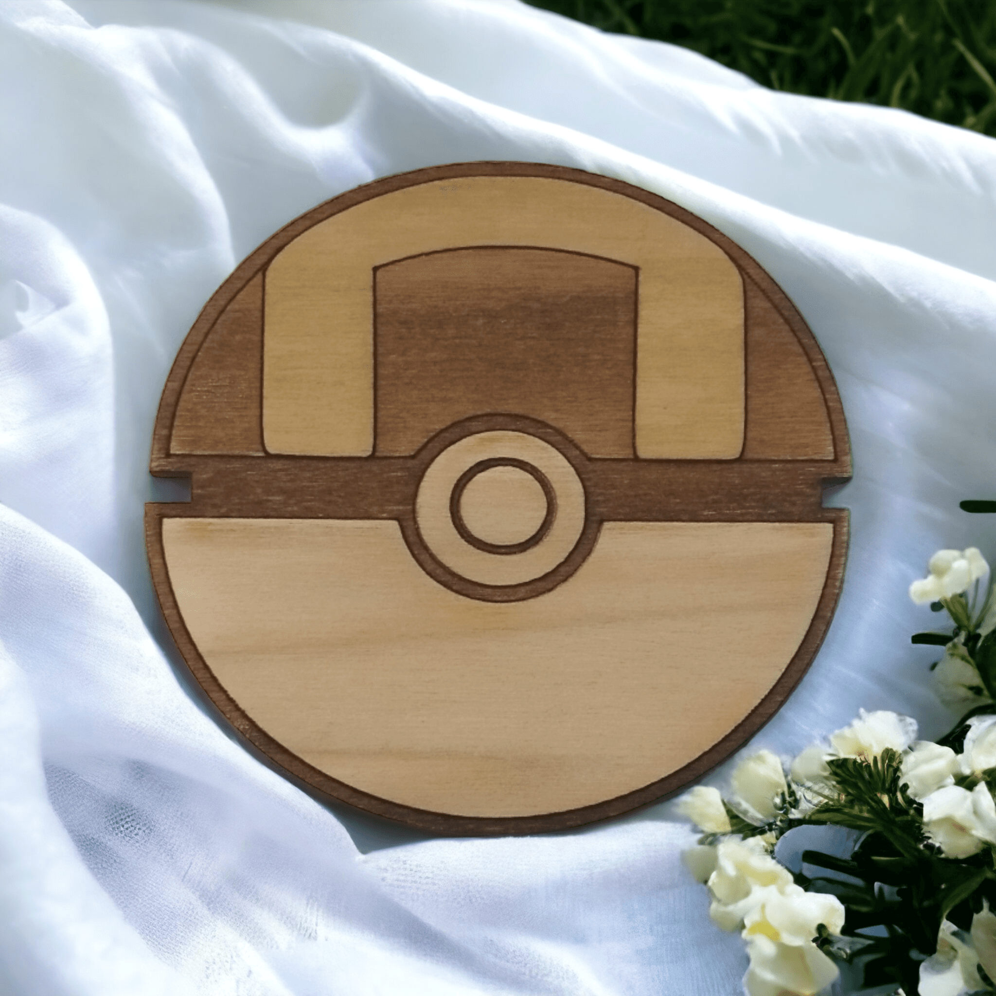 Hand holding a handmade Pokeball wooden coaster with detailed design