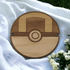 Hand holding a handmade Pokeball wooden coaster with detailed design